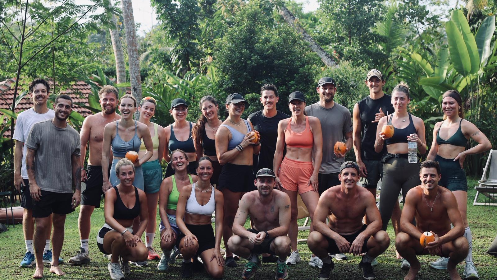 The run club after a morning loop — the whole group on the lawn with fresh coconuts